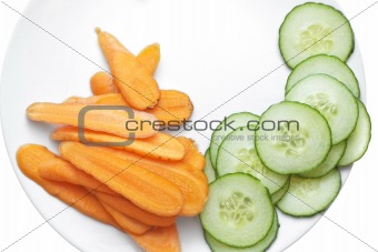 Carrot and cucumber slices in white plate.