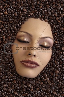 girl's face immersed in coffee beans 