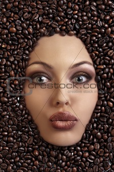 portrait of a pretty girl laying among coffee beans