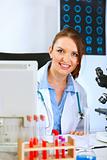 Smiling medical doctor woman looking out from monitor
