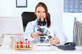 Smiling doctor woman using microscope in laboratory
