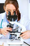 Woman researcher using microscope in medical laboratory. Close up
