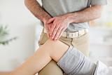 Chiropractor massaging a cute woman's knee