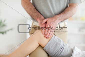 Chiropractor massaging a charming woman's knee