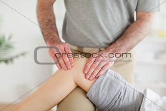 Male Chiropractor massaging a charming woman's knee