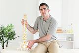 Chiropractor holding the model of a spine