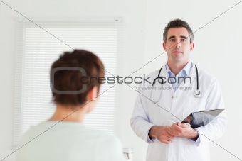 Serious Doctor talking to a brunette woman