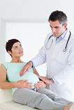 Doctor examining a pregnant woman's tummy