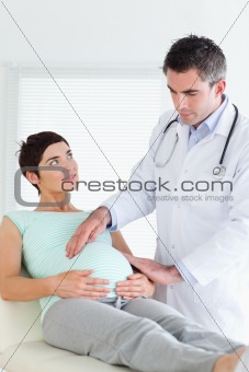 Doctor examining a pregnant woman's tummy