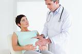 Doctor ausculating a pregnant woman's belly