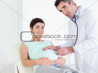 Doctor examining a tummy with a stethoscope