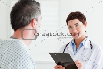 Doctor talking to a male patient holding a chart