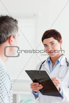 Doctor talking to a male patient while holding a chart