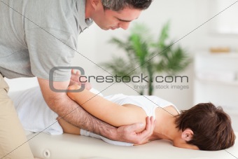 Brunette woman getting a shoulder-stretching