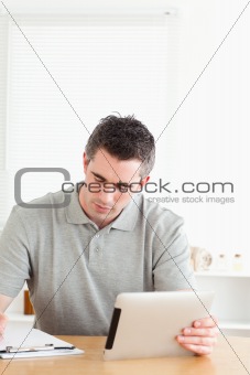Doctor sitting at a table with a tablet and a chart