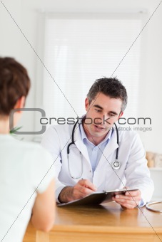 Handsome Doctor talking to a brunette patient