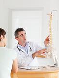 Doctor showing a female patient a part of a spine