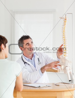 Doctor showing a female patient a part of a spine