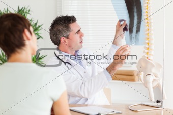 Male Doctor showing a female patient a x-ray