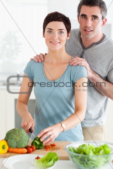 Husband massaging his wife while she's cutting vegetables
