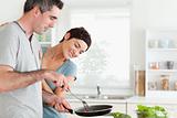 Woman looking into a pan her husband is holding