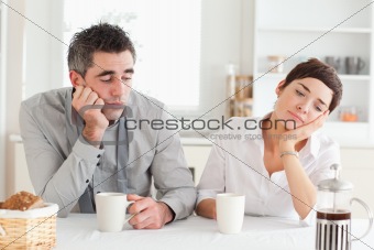 Exhausted couple drinking coffee