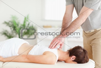 Masseur massaging a female customer's back