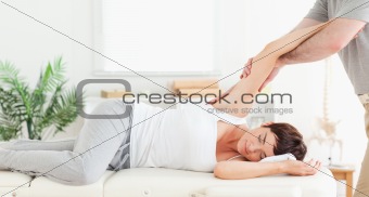 Chiropractor stretching woman's arm
