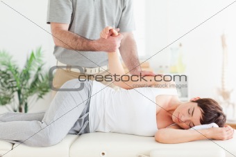 Chiropractor stretches female customer's arm
