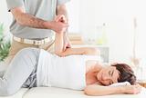 Chiropractor stretches a customer's arm