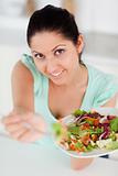 Cute young woman offering salad