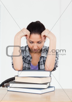 Frustrated young student resting on books