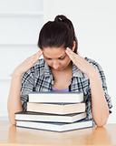 Frustrated young student leaning on books