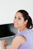 Cheerful young woman sitting at laptop