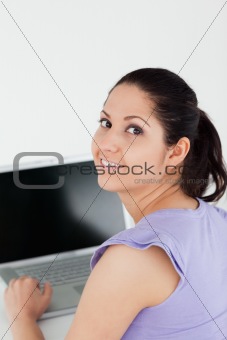 Cheerful young woman sitting at laptop