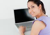 Pretty young woman sitting by laptop