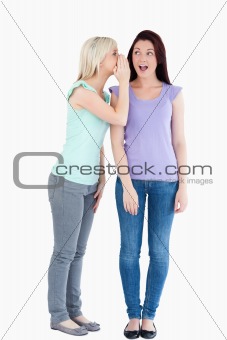 Beautiful woman telling her friend a secret