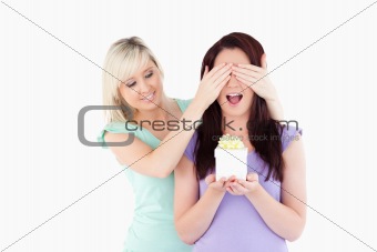 Young woman  giving a gift to her friend