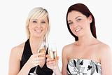 Cute women in beautiful dresses toasting with champaign
