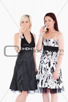 Beautiful women in dresses drinking champaign