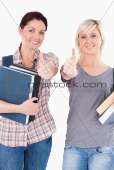 Students with books and thumbs up