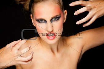Mysterious woman with extravagant makeup and scaring expression
