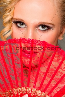 Portrait of girl closing face with textile fan
