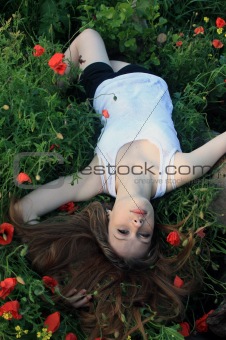 Passionate girl lying on the poppies