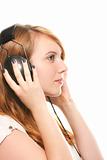 young dreamy redhead woman listening to music with he
r headphones