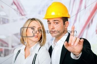 Male female architects pointing