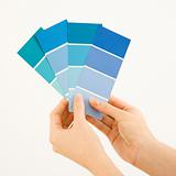 Woman holding paint swatches.