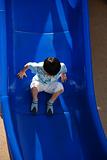 child playing slide in the play ground