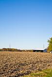 Tilled Field With Farm Building