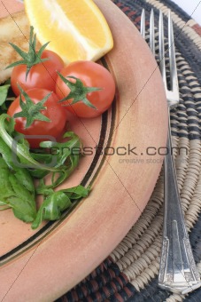 Stoneware plate and salad on African mat
